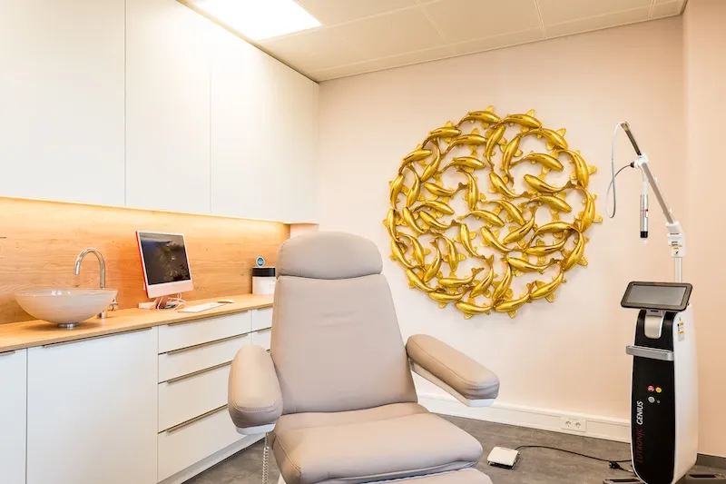 Behandlungsraum mit Goldskulptur und Lasergerät